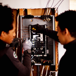 two men working on an electrical box
